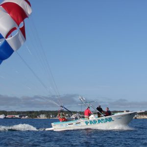 a man flying a kite in a boat on a body of water