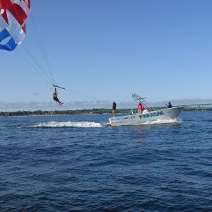 a man flying a kite in a large body of water