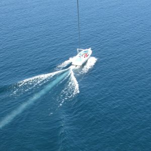 a man riding on the back of a boat in a body of water